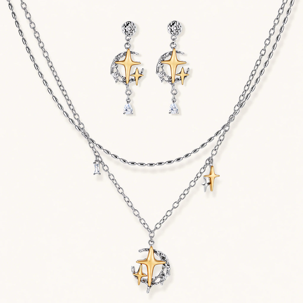 Delicate eco-brass jewelry set featuring gold star and silver moon crescents with clear zirconia crystal drops on cream background