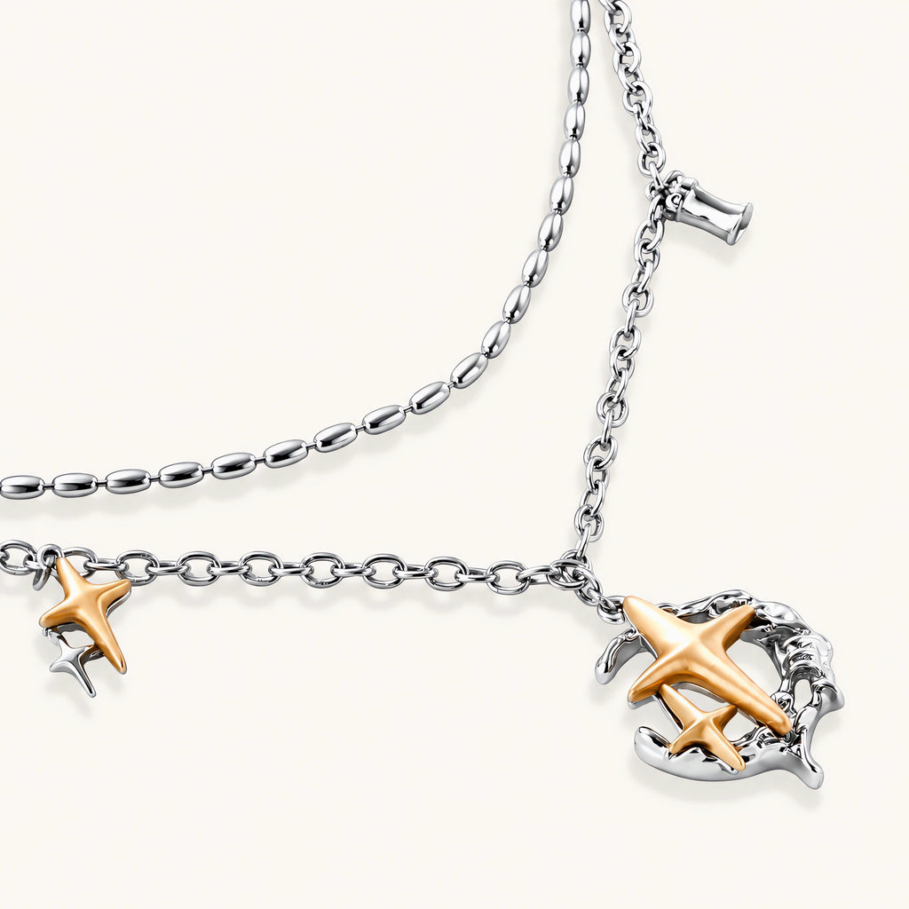 Delicate eco-brass jewelry set featuring gold star and silver moon crescents with clear zirconia crystal drops on cream background