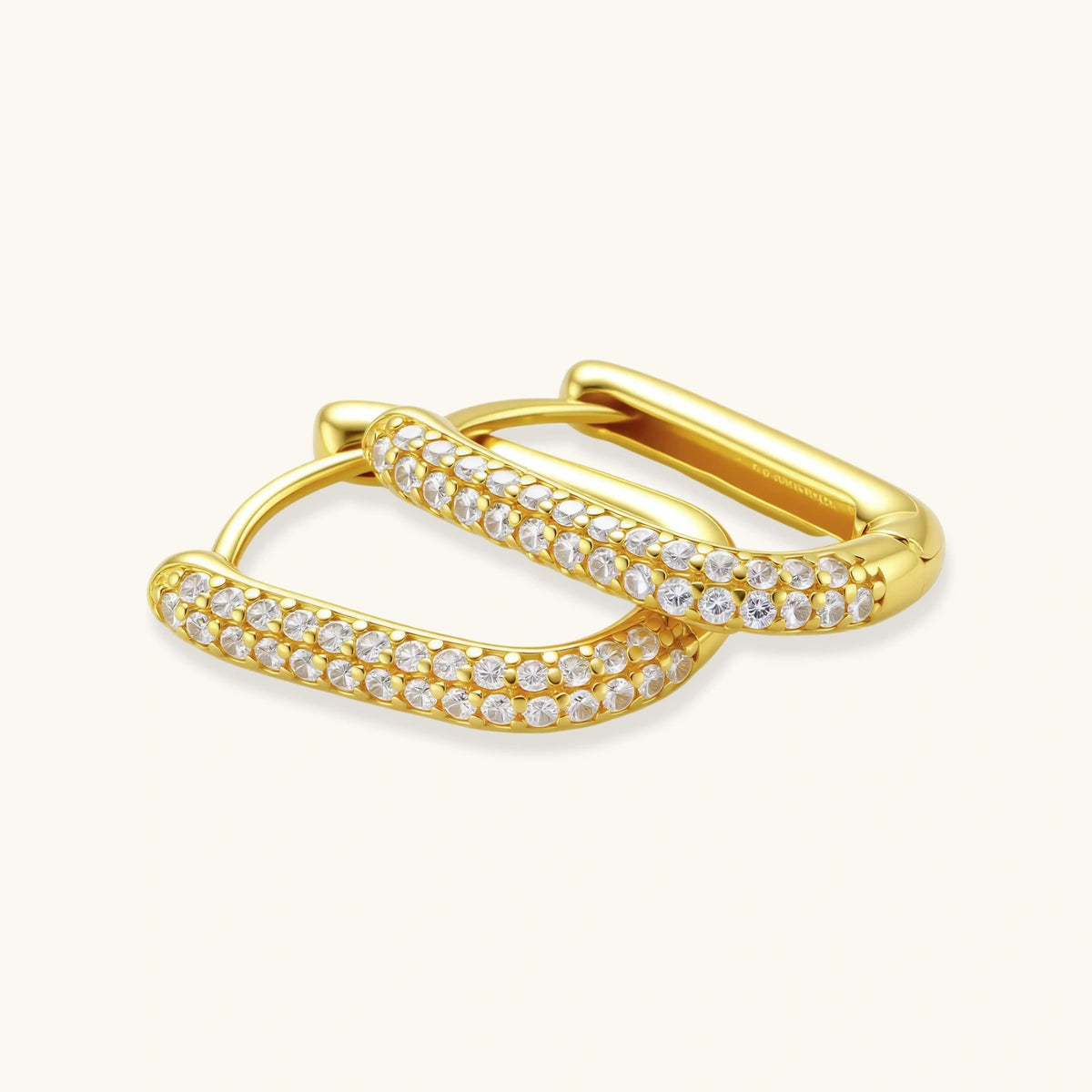 Close-up of gold-plated sterling silver huggie earrings with pave-set crystals creating a continuous sparkle around the hoop