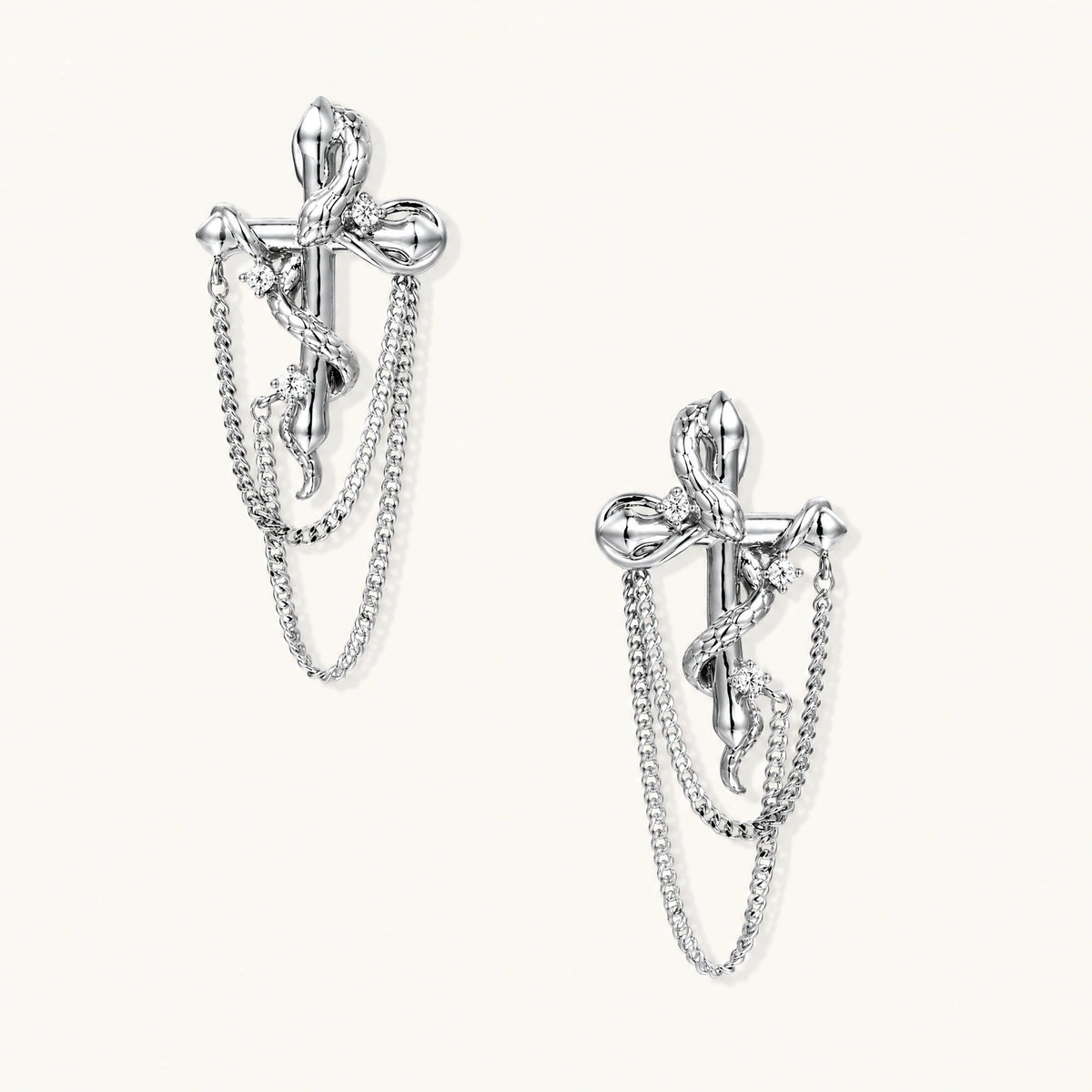 Sculptural white gold bow earrings with cascading chain details on neutral background