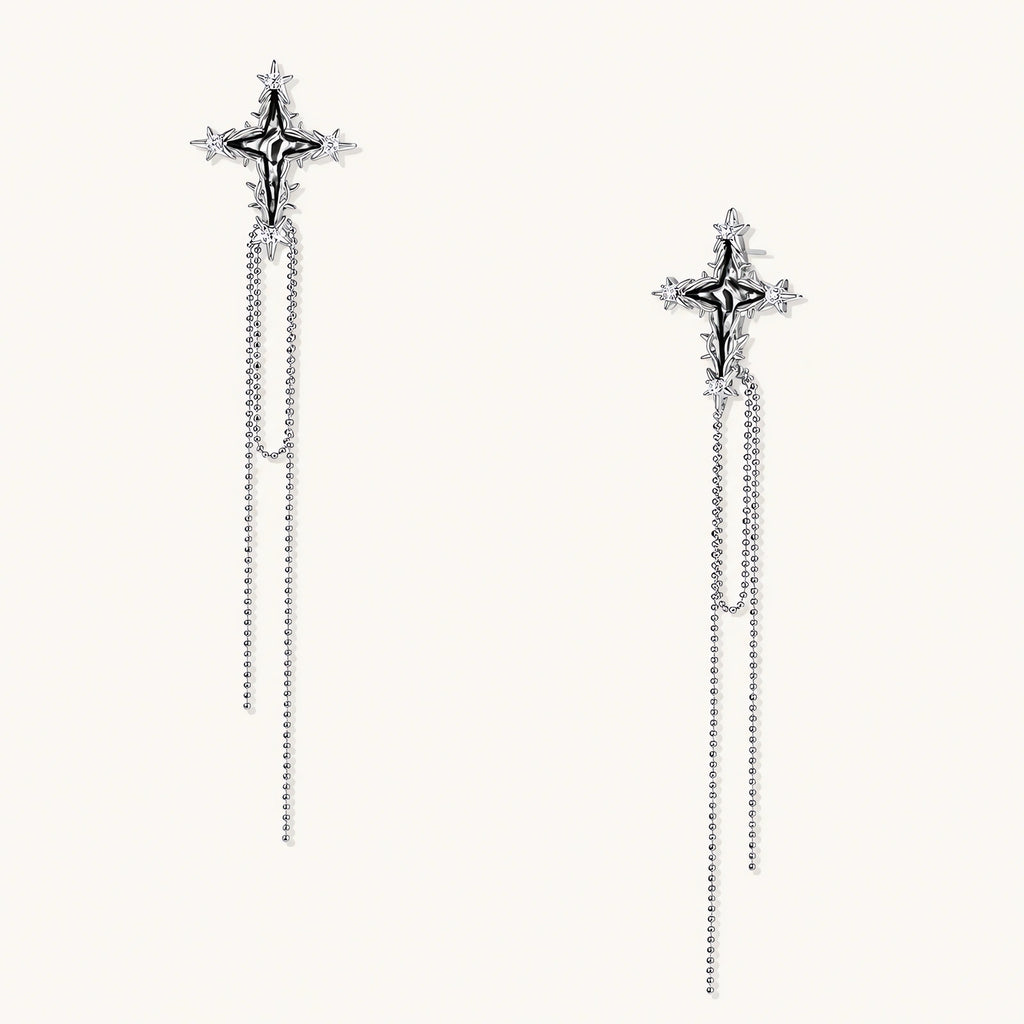 Long silver threader earrings with ornate cross-star design and delicate dual chain tassels on white background