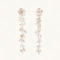 Long sterling silver drop earrings with delicate floral vine design and crystal accents on white background