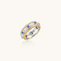 Two-tone ring with brushed silver center, gold beaded edges, and blue zirconia stones on white background.