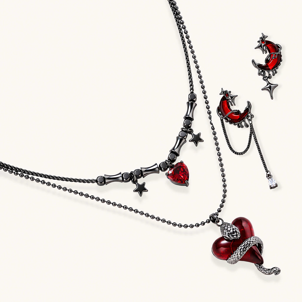 Gothic jewelry set with asymmetrical black metal earrings featuring red crescent moons, stars, and layered necklaces with heart pendants