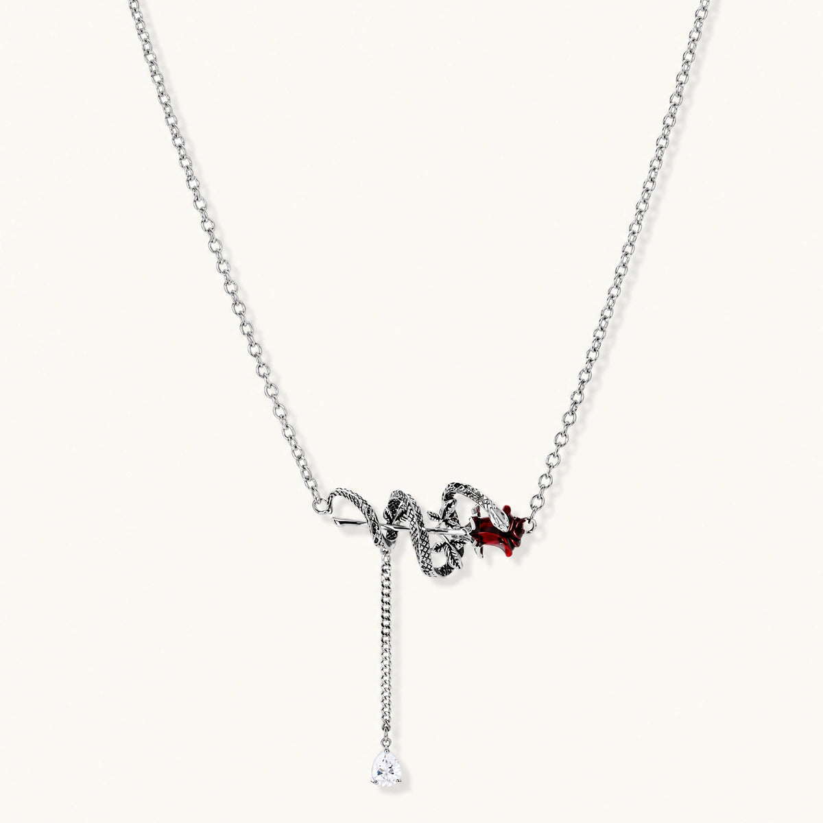 Gothic jewelry set with silver snake designs holding red enamel roses, featuring detailed leaf stems on cream background