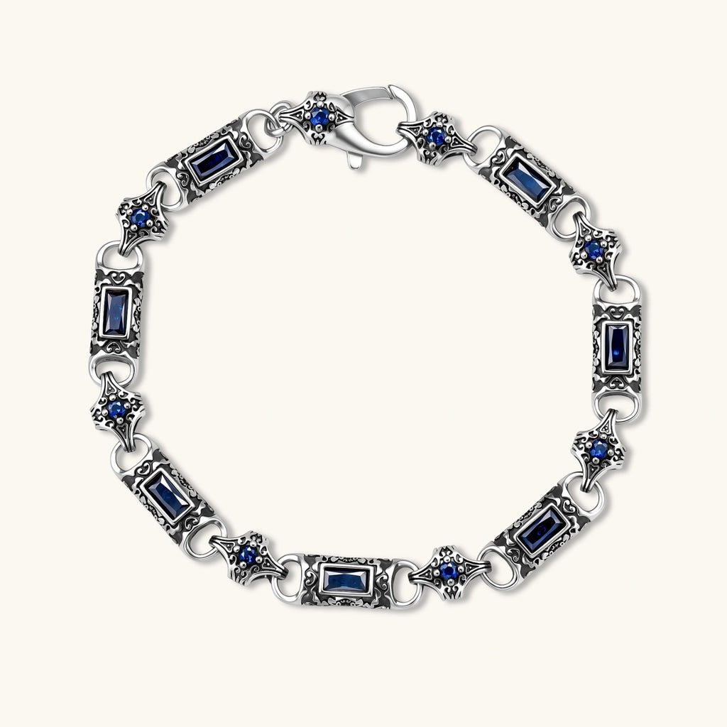 Antique silver plated eco-brass link bracelet with engraved scrollwork, blue baguette cubic zirconia and a lobster clasp.