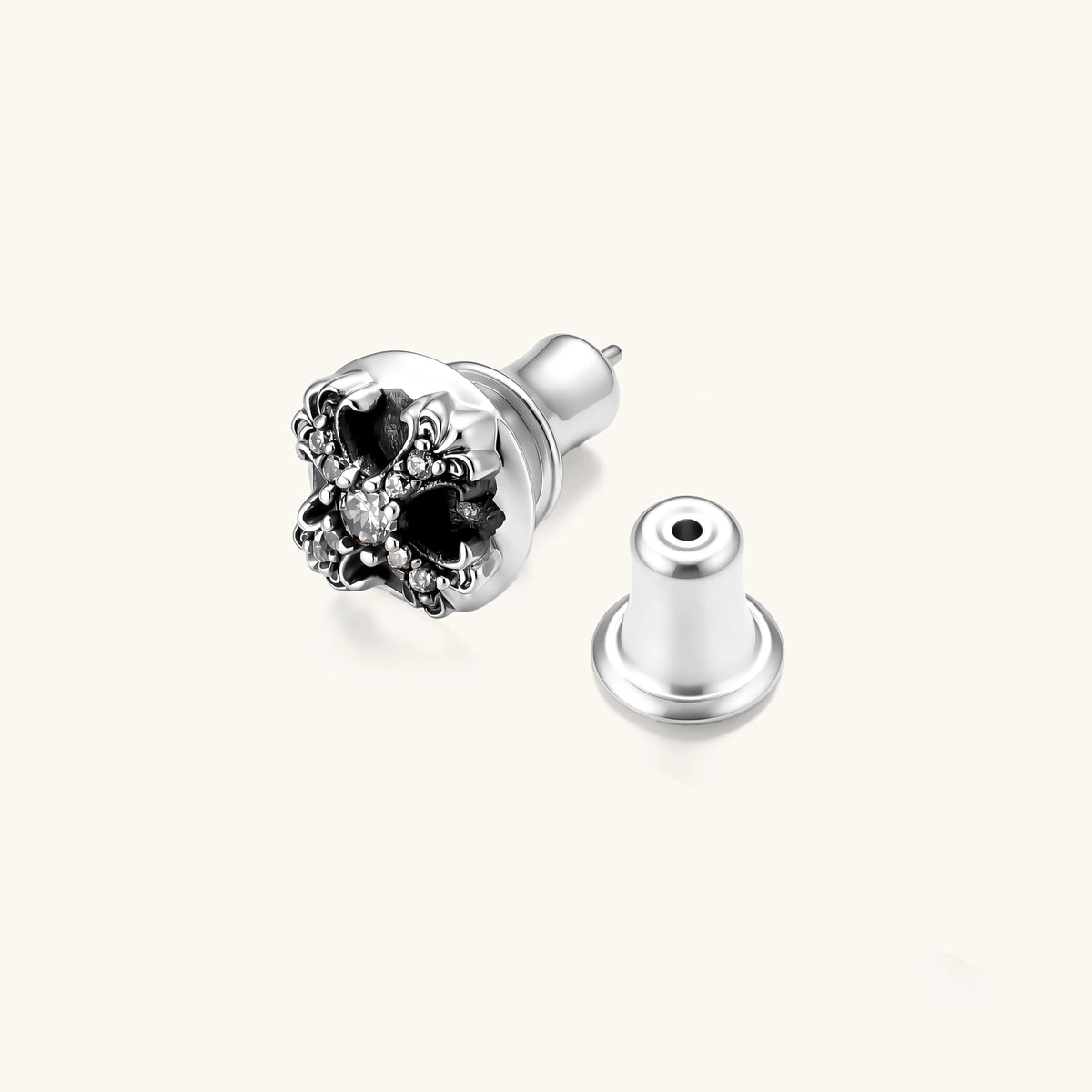 Sterling silver dome stud earring with oxidized black petals, ornate scrollwork, and clear cubic zirconia stones, butterfly back.